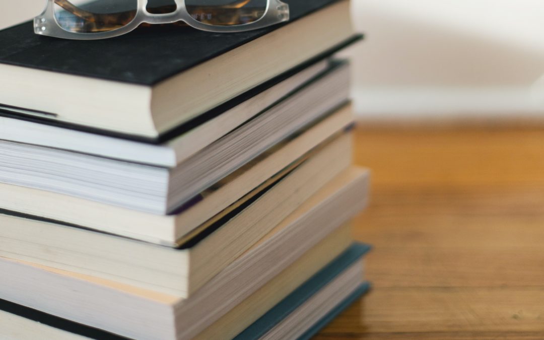 books with glasses on top